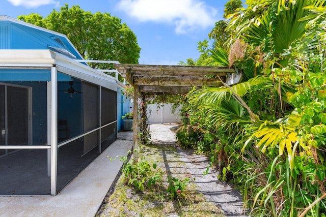 view of yard featuring a sunroom and a pergola