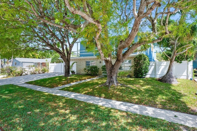 view of property hidden behind natural elements with driveway