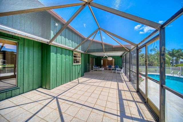 unfurnished sunroom with a ceiling fan and vaulted ceiling