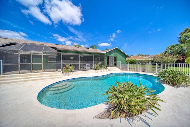 view of swimming pool with fence, a patio, and glass enclosure
