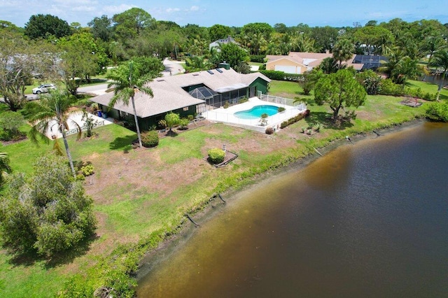 aerial view of property and surrounding area with a pool area, a large body of water, and a tree filled landscape