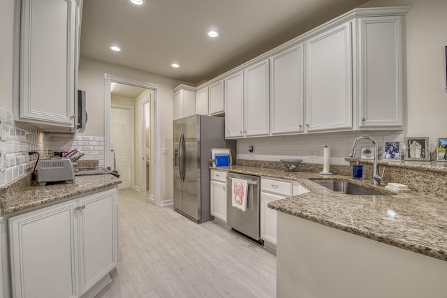 1330 S Jeaga Dr, Jupiter, FL 33458 - kitchen with appliances with stainless steel finishes, a sink, decorative backsplash, light stone counters, and light wood-type flooring
