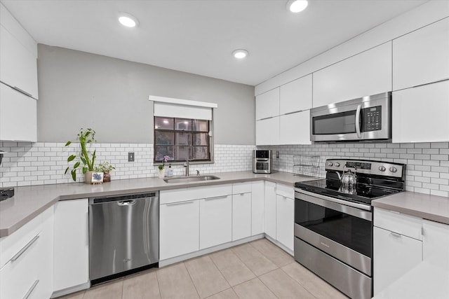 184 NW 115th Ter, Plantation, FL 33325 - kitchen featuring stainless steel appliances, a sink, white cabinets, tasteful backsplash, and recessed lighting