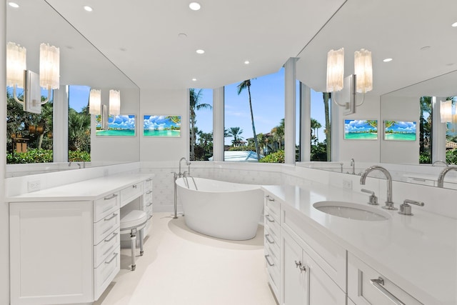 full bathroom with recessed lighting, a soaking tub, and vanity
