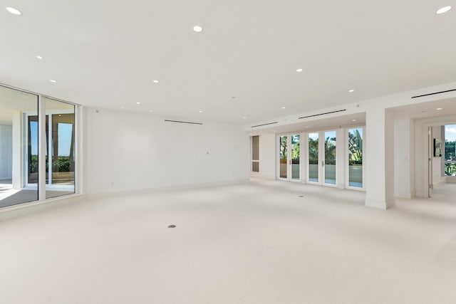 unfurnished room with light colored carpet, recessed lighting, and baseboards