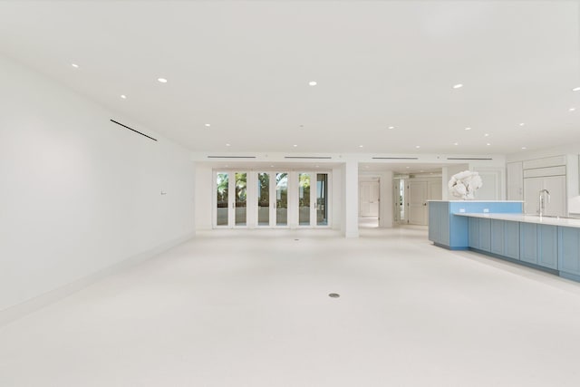 unfurnished living room with recessed lighting and a sink