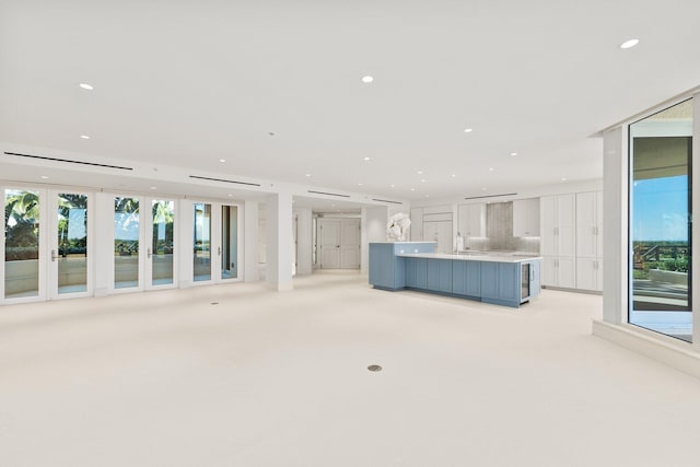 unfurnished living room featuring plenty of natural light, light colored carpet, and recessed lighting