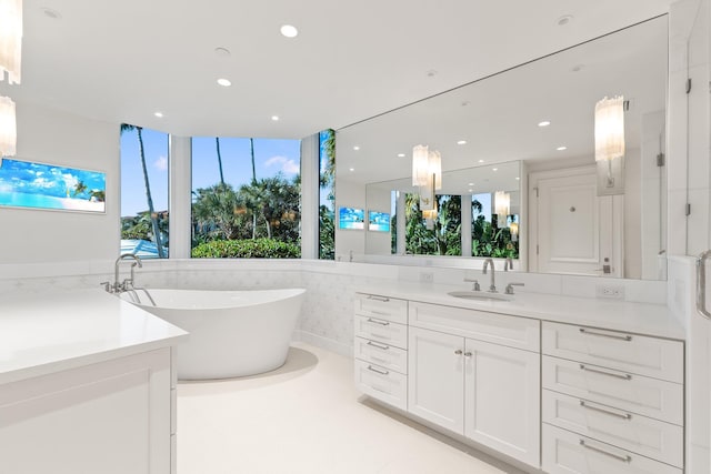 full bathroom featuring vanity, a freestanding tub, and recessed lighting