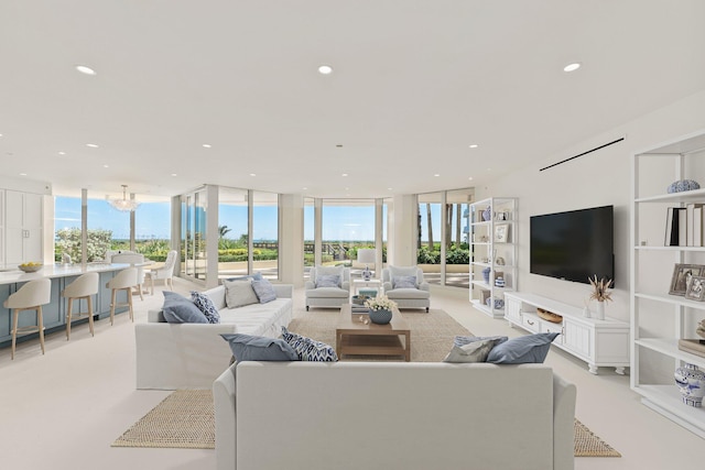 living room with recessed lighting, a wall of windows, and a chandelier