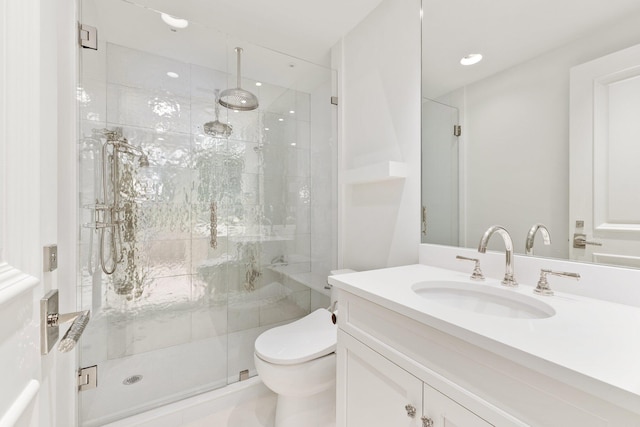 bathroom featuring a stall shower, toilet, and vanity