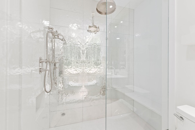 full bathroom featuring toilet and tiled shower