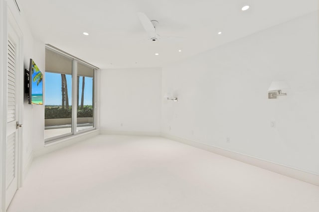 carpeted spare room featuring recessed lighting, a ceiling fan, and baseboards