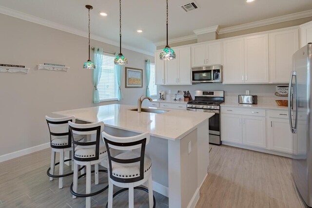 745 SE Bloomfield Rd, Port Saint Lucie, FL 34984 - kitchen featuring stainless steel appliances, a sink, ornamental molding, white cabinets, and light countertops