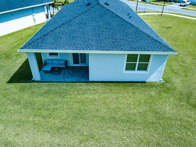 745 SE Bloomfield Rd, Port Saint Lucie, FL 34984 - rear view of house featuring roof with shingles, stucco siding, and a lawn
