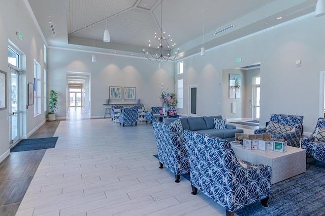 745 SE Bloomfield Rd, Port Saint Lucie, FL 34984 - living room featuring a towering ceiling, a chandelier, a raised ceiling, baseboards, and wood finished floors