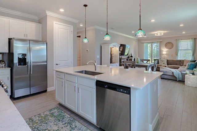 745 SE Bloomfield Rd, Port Saint Lucie, FL 34984 - kitchen with stainless steel appliances, a sink, open floor plan, white cabinets, and a center island with sink