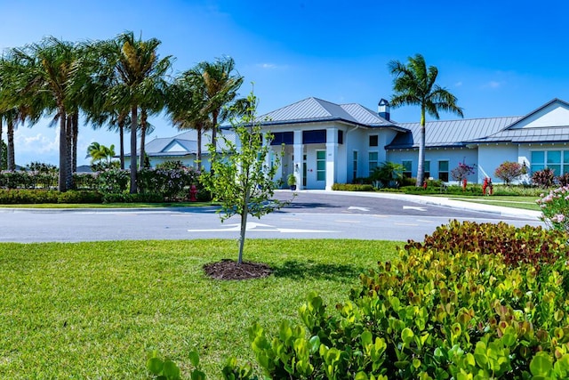 745 SE Bloomfield Rd, Port Saint Lucie, FL 34984 - view of front of property with stucco siding, a standing seam roof, a front lawn, and metal roof