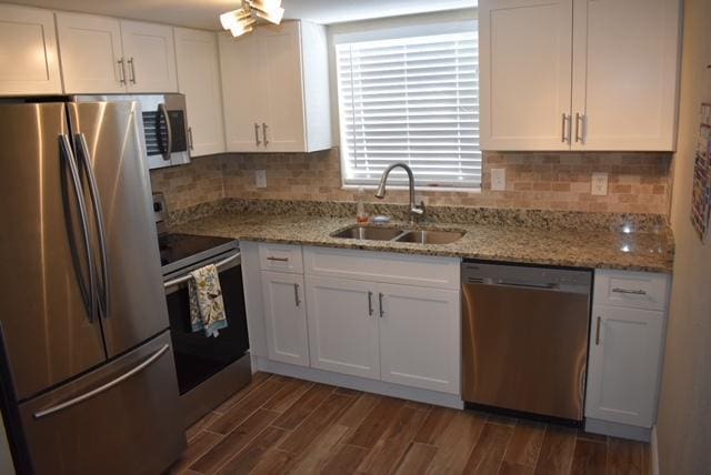 kitchen featuring stainless steel appliances, a sink, and white cabinets