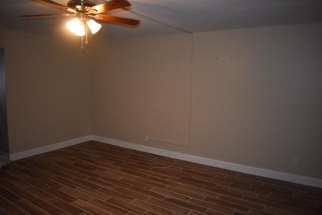 unfurnished room featuring ceiling fan, wood finished floors, and baseboards