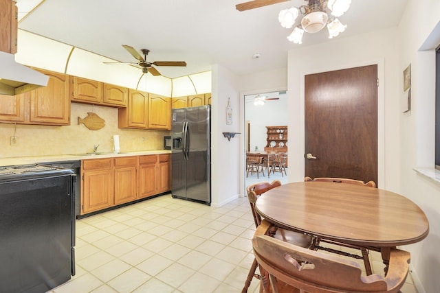 kitchen featuring stainless steel fridge with ice dispenser, range, a ceiling fan, light countertops, and a sink