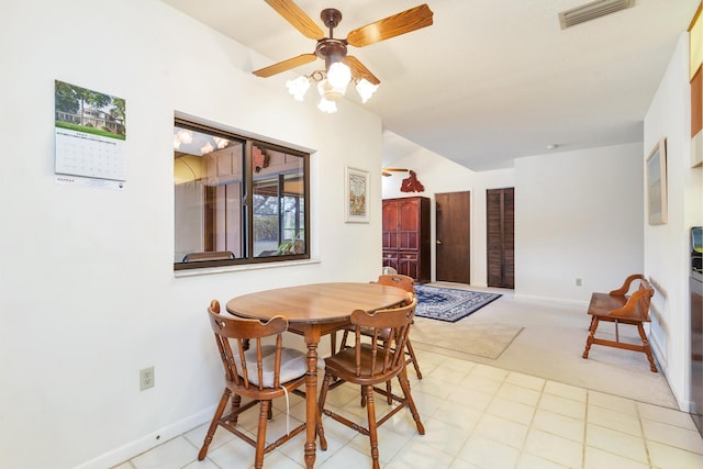dining space featuring baseboards, ceiling fan, and light colored carpet