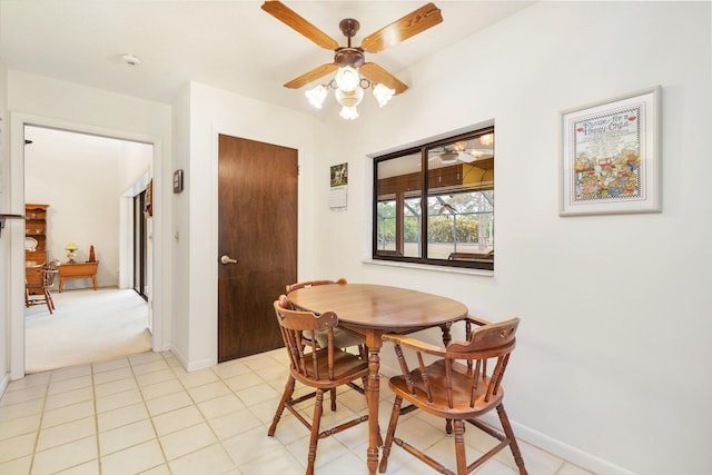 dining area featuring a ceiling fan, baseboards, and light tile patterned floors