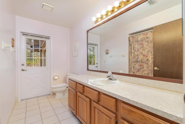bathroom featuring tile patterned flooring, toilet, and vanity