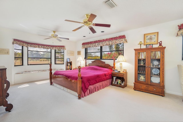 carpeted bedroom with ceiling fan and baseboards
