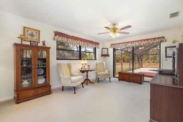 sitting room with a ceiling fan, carpet floors, and baseboards