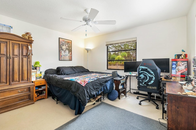 carpeted bedroom featuring a ceiling fan and an office area