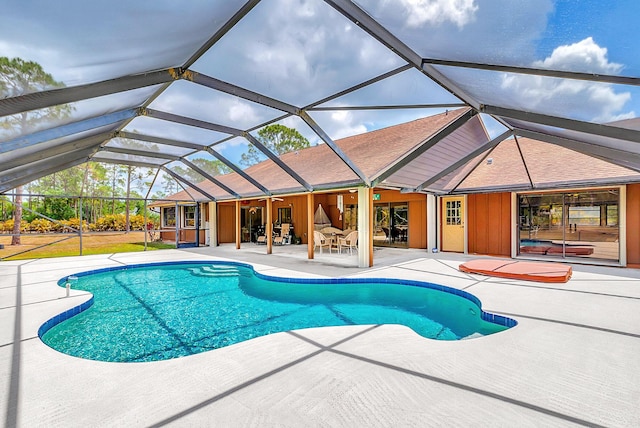 swimming pool with a patio area, a lanai, and a ceiling fan
