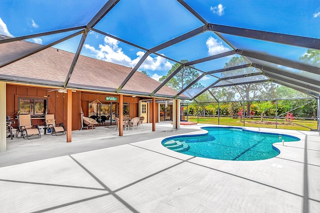 swimming pool with a patio area, ceiling fan, and glass enclosure