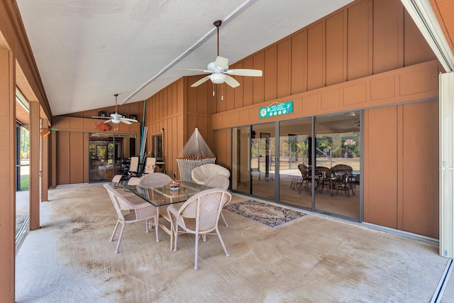 sunroom featuring a ceiling fan, lofted ceiling, and outdoor dining space