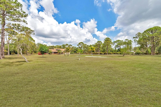 view of property's community with a lawn and view of scattered trees