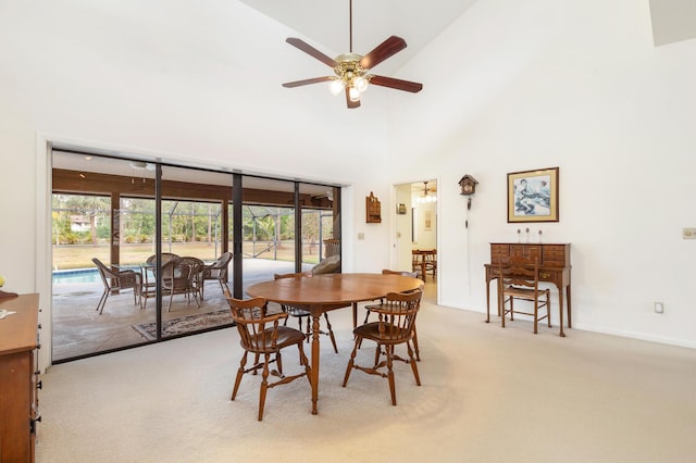 carpeted dining room with a ceiling fan, high vaulted ceiling, and baseboards