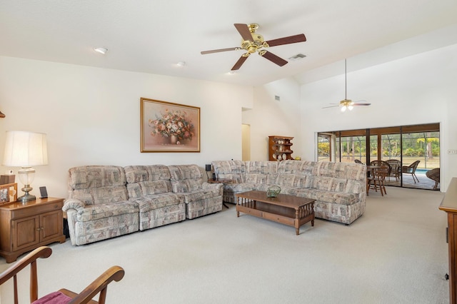 carpeted living area with ceiling fan and lofted ceiling