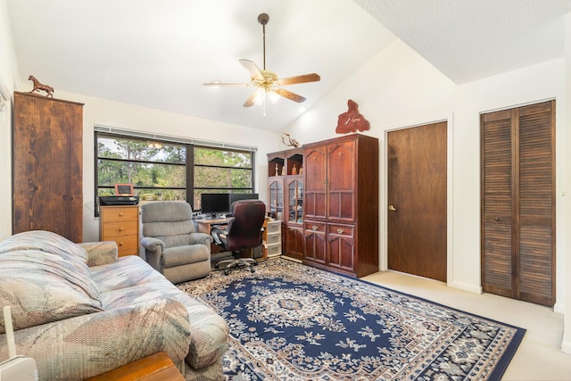 carpeted home office with a ceiling fan and lofted ceiling