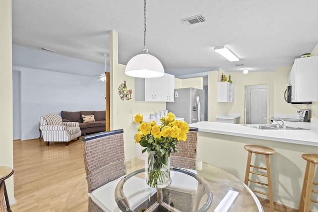 6527 Alheli, Fort Pierce, FL 34951 - dining room featuring light wood-style floors, a ceiling fan, and a textured ceiling