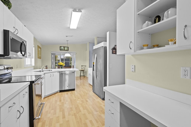 6527 Alheli, Fort Pierce, FL 34951 - kitchen with appliances with stainless steel finishes, light wood-style flooring, a sink, light countertops, and white cabinetry