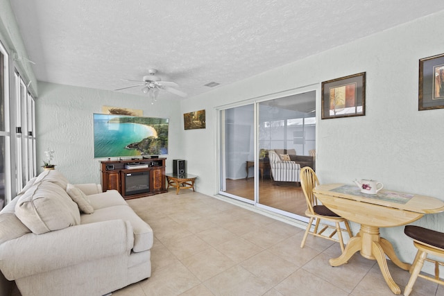 6527 Alheli, Fort Pierce, FL 34951 - tiled living room featuring a textured wall, a ceiling fan, and a textured ceiling