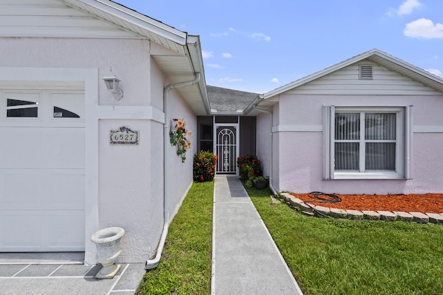 6527 Alheli, Fort Pierce, FL 34951 - doorway to property featuring an attached garage, stucco siding, and a lawn