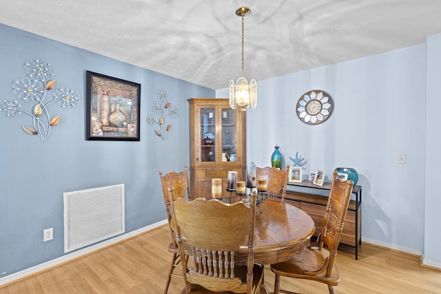 6527 Alheli, Fort Pierce, FL 34951 - dining area featuring a chandelier, light wood-style flooring, and baseboards