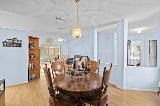 6527 Alheli, Fort Pierce, FL 34951 - dining space featuring light wood-type flooring, baseboards, ceiling fan, a textured ceiling, and a chandelier