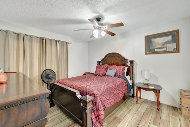 555 SW Sara Blvd, Port Saint Lucie, FL 34953 - bedroom with light wood-style floors, a textured ceiling, a ceiling fan, and baseboards