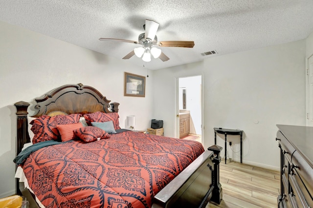 555 SW Sara Blvd, Port Saint Lucie, FL 34953 - bedroom featuring light wood-style floors, a textured ceiling, baseboards, ceiling fan, and connected bathroom