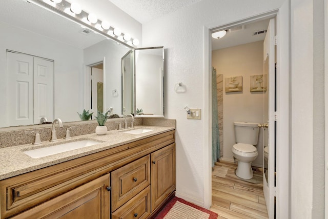 555 SW Sara Blvd, Port Saint Lucie, FL 34953 - bathroom featuring wood finished floors, toilet, double vanity, and a shower with curtain
