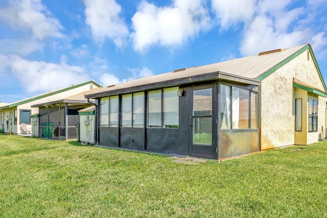 555 SW Sara Blvd, Port Saint Lucie, FL 34953 - rear view of property featuring a sunroom, a yard, and stucco siding