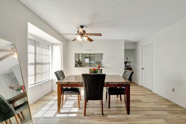 555 SW Sara Blvd, Port Saint Lucie, FL 34953 - dining room with ceiling fan, light wood-style floors, a textured ceiling, and baseboards