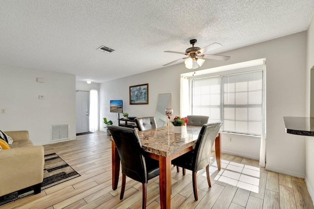 555 SW Sara Blvd, Port Saint Lucie, FL 34953 - dining area with light wood-style floors, a ceiling fan, a textured ceiling, and baseboards