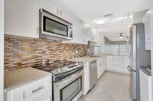 1131 Violet Ter Unit 104, Delray Beach, FL 33445 - kitchen with stainless steel appliances, white cabinets, tasteful backsplash, and a sink